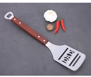 Stainless steel BBQ spatula with wooden handle, built-in bottle opener and DAD cutout design for grilling.
