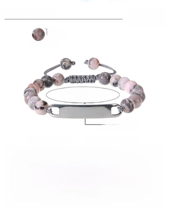 Detail of adjustable woven rope bracelet with 8mm pink zebra stones and engraved bar