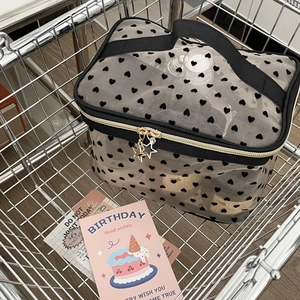 Mesh makeup bag with black hearts and star zippers shown in a metal shopping cart