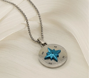 Detailed macro view of the compass pendant featuring a blue star and engraved coordinates