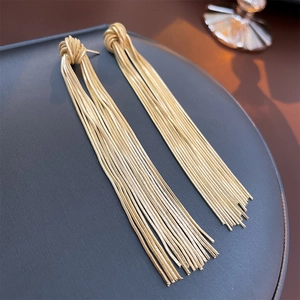 Detailed view of long gold tassel earrings with knot design and multi-strand metal chains