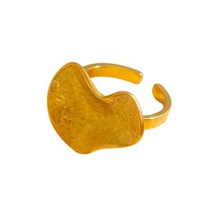Detail of golden heart ring featuring irregular hammered texture and adjustable open band