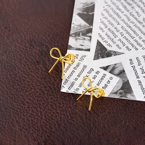 Boucles d'oreilles nœud dorées en acier titane avec un design de nœud papillon minimaliste