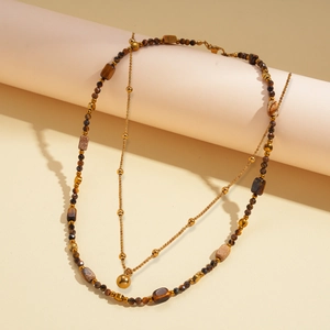 Detail of 18k gold plated double layer necklace with tiger eye beads and golden pendant