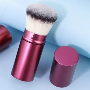 Detail of retractable magenta makeup brush with soft dual-tone synthetic bristles