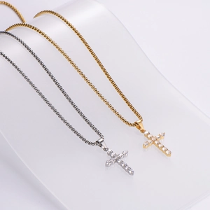 Polished gold and silver cross necklaces with cubic zirconia on a glass wave stand