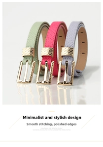 Close-up of thin leather belts with crocodile texture and golden buckle details