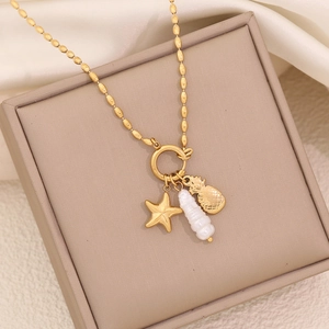 Golden bead chain necklace featuring starfish, shell, and pineapple charms on a soft beige base
