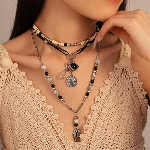 Detail of bohemian layered necklace with vintage beads, metal chains and coin charms