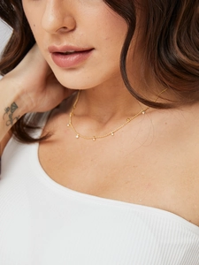 Minimalist gold plated necklace featuring small white zircon beads worn on neck