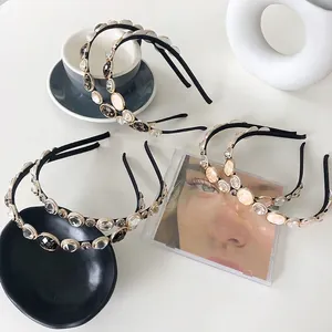 Retro rhinestone headband set with pearl and crystal embellishments on a white desk