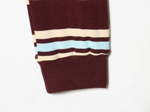 Detail of ribbed knit cuffs with burgundy, off-white and light blue striped stitching