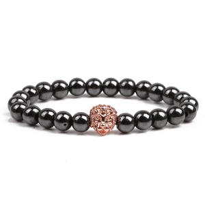 Detail of dark grey hematite bead bracelet featuring a rose gold lion head charm accent