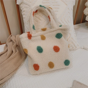 Close-up of fluffy sherpa tote bag with colorful 3D polka dots and cozy texture