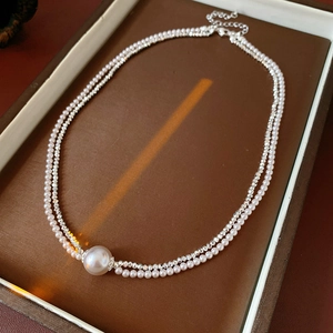 Detail of double-layer pearl necklace with sparkling crystal chain in a jewelry box