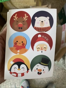 Detail shot of round Christmas stickers with Santa, reindeer, and gingerbread man patterns