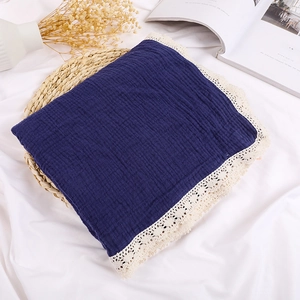 Close-up of navy blue double-layer cotton muslin baby blanket with white lace trim