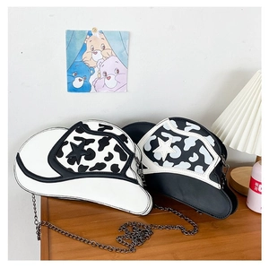 Detail of creative cowboy hat shaped crossbody bags with cow print and star accents