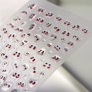 Detailed macro view of 3D embossed jelly nail stickers with funny cartoon eye designs