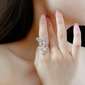 Macro detail of silver hollow butterfly ring with micro-pave zircons and tiered design