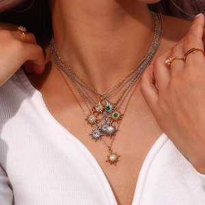 Detail of layered necklaces with starburst pendants and colorful gemstone settings