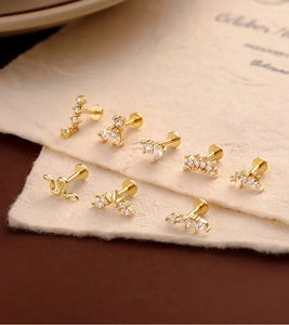 Macro detail of various gold-plated zircon labret earrings for ear cartilage piercing