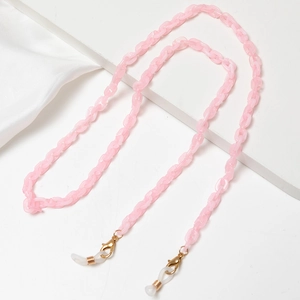 Close-up of pink acrylic eyewear chain with golden lobster clasps and white silicone loops
