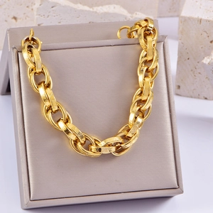 Detail of chunky gold chain bracelet with large oval links on a display stone