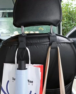 Detail view of black dual car seat hooks installed on headrest for bags and umbrellas