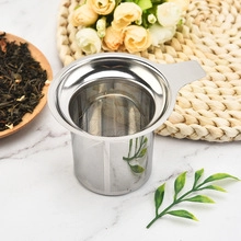 Detail of 304 stainless steel pipe-shaped tea infuser on marble background with dry tea leaves