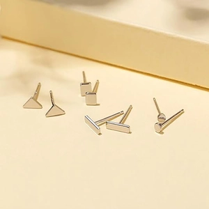 Collezione dettagliata di orecchini a lobo geometrici in acciaio argento in quattro forme