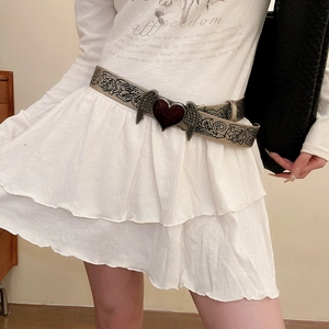 Detail of vintage heart and wings buckle with floral embossed khaki leather belt