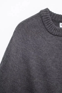 Detail shot of the round neckline and fine knit texture on the dark gray cardigan sweater