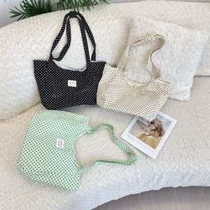 Three canvas tote bags with polka dot prints in black, cream, and mint green