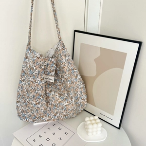 Close-up of floral fabric tote bag with aesthetic label and vintage paisley patterns