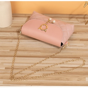 Detail of pink quilted small bag featuring cat ear ring buckle with pearl charms