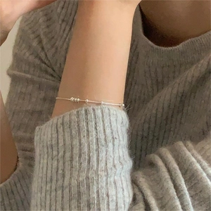 Detail of minimalist S925 sterling silver snake chain bracelet on a person's wrist