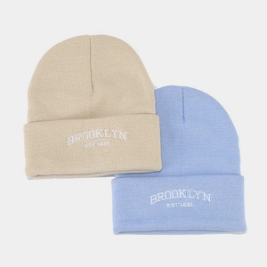 Close-up of beige and light blue knit beanies with Brooklyn 1634 letter embroidery