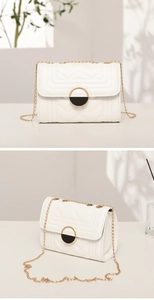 Detail of white quilted crossbody bag with golden chain strap and round metallic buckle
