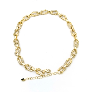 Detail of gold chain necklace with alternating cubic zirconia encrusted links and lobster clasp