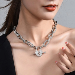 Macro shot of silver titanium steel necklace with diamond-encrusted arrow through heart pendant