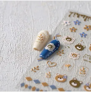 Close-up of 3D embossed nail art stickers featuring bears and floral vine patterns