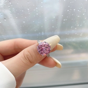 Detailed close-up of a pink round gemstone ring with side diamonds on silver band