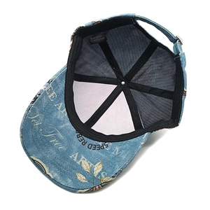 Detail of blue denim baseball cap showing retro lettering and adjustable metal buckle