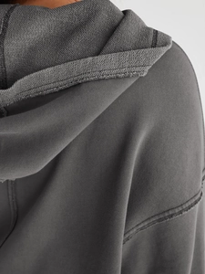 Nahaufnahme des dunkelgrauen Hoodies mit Stricktextur und hochwertigen Nahtdetails