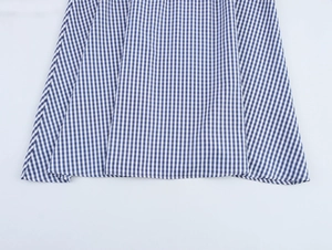 Detail of blue and white plaid fabric texture and hemline of the pleated maxi dress