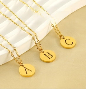 Detailed macro view of 18K gold plated stainless steel letter disc pendant on O-chain