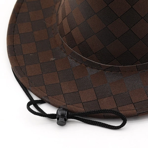 Detailed macro view of checkered cowboy hat texture with black adjustable chin strap cord