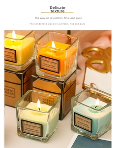 Close-up of pastel colored square glass scented candles with minimalist black labels