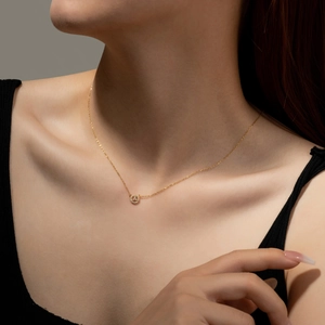 Minimalist s925 sterling silver necklace with a tiny golden round pendant on a model